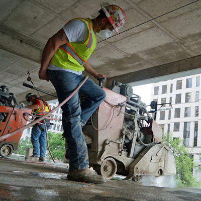 Concrete Operator cutting up concrete slab inside parking garage in downtown Austin, TX.