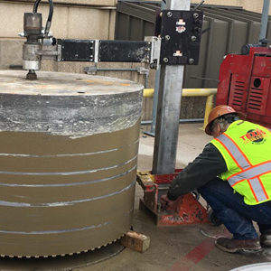 Texas Cutting and Coring technician making some fine adjustments to the alignment wheels as they continue to drill the 62" round hole out at the Dallas Fort Worth Airport